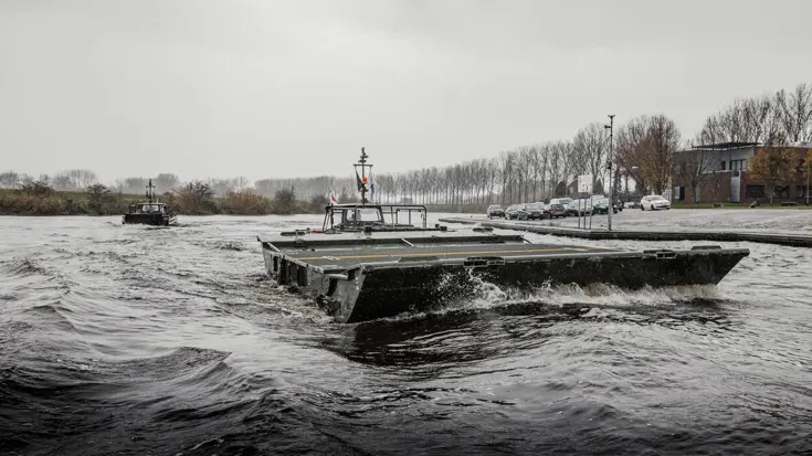 Ponton met oude vaartuig op de achtergrond.