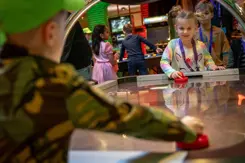 Kinderen spelen airhockey.