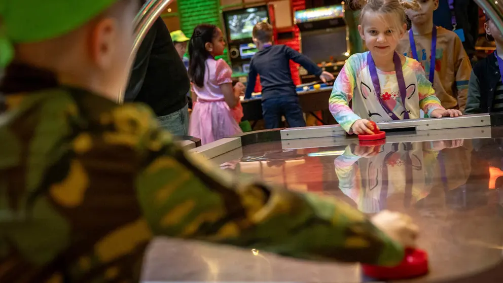 Kinderen spelen airhockey.