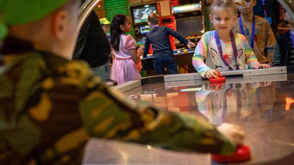 Kinderen spelen airhockey.