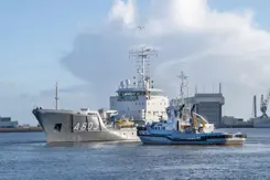Een varende Zr.Ms. Luymes met een sleepboot erbij.
