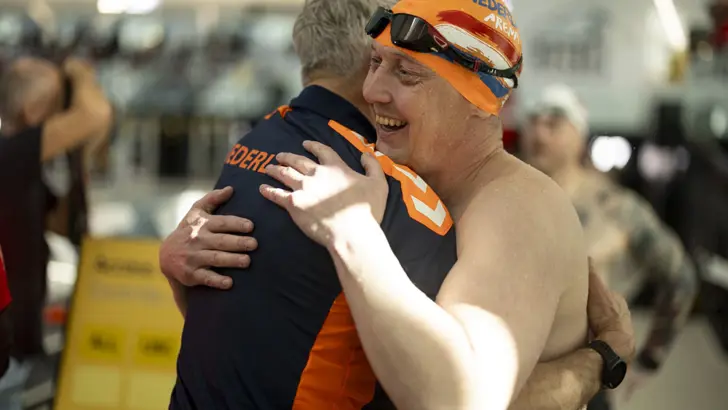 2 sporters omhelzen elkaar.