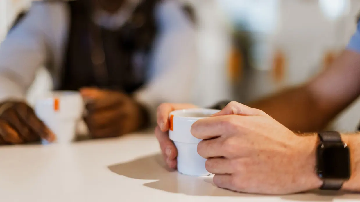 Marechaussee met een koffiekopje in zijn hand.