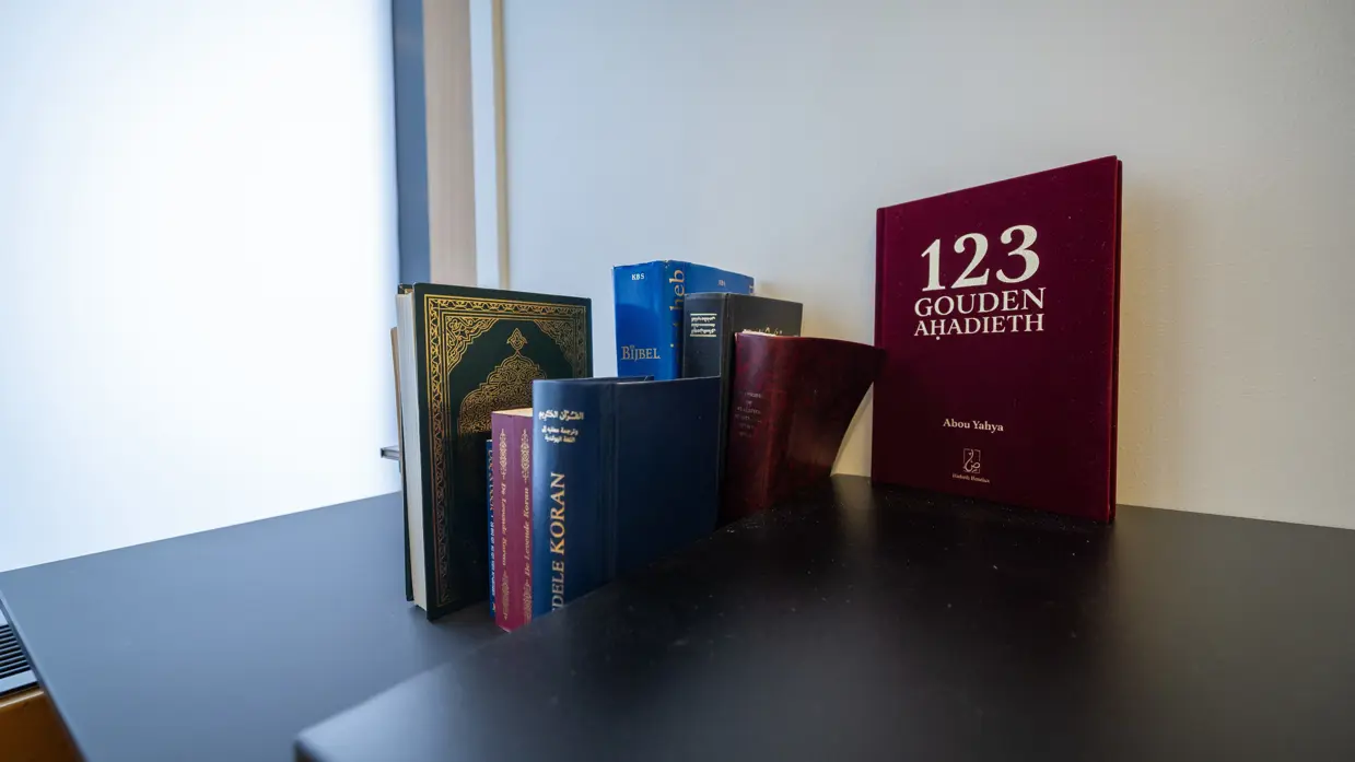 Een kast met daarop heilige boeken van diverse religies.