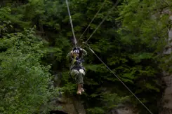Militair daalt tussen de bomen af met een zipline.
