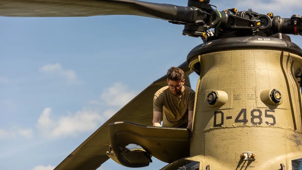 Monteur in de buitenlucht aan het werk aan een gearbox van een Chinook.