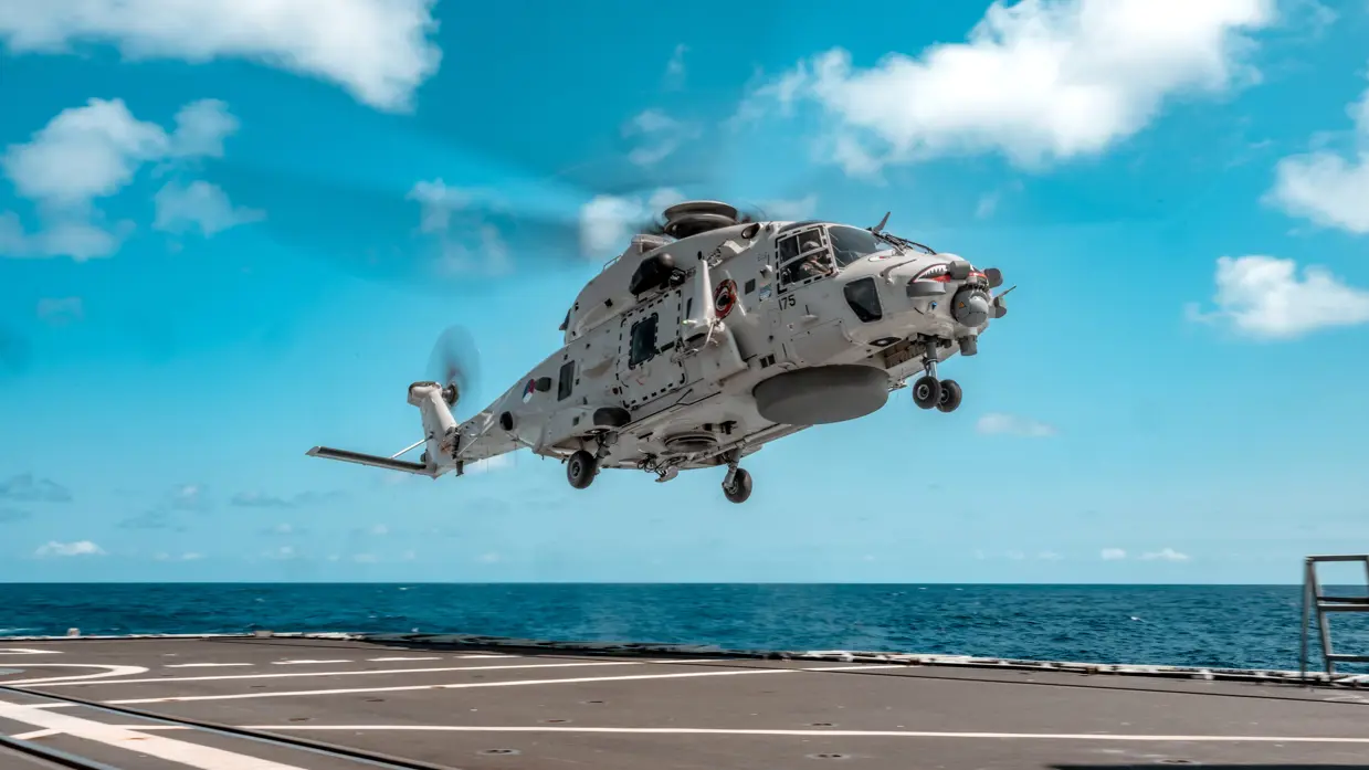 NH90 vlak boven een vliegdek van een schip op zee.