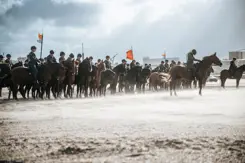 Ruiters te paard op het strand.