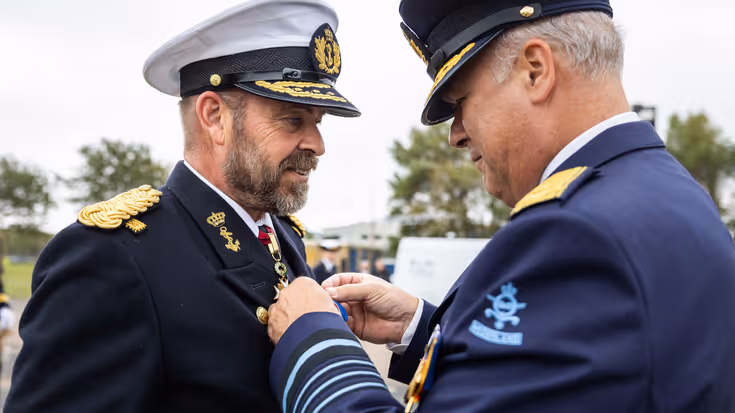 Tas krijgt het ereteken opgespeld door Onno Eichelsheim. 