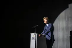 Minister Ruben Brekelmans tegen donkere achtergrond achter katheder.