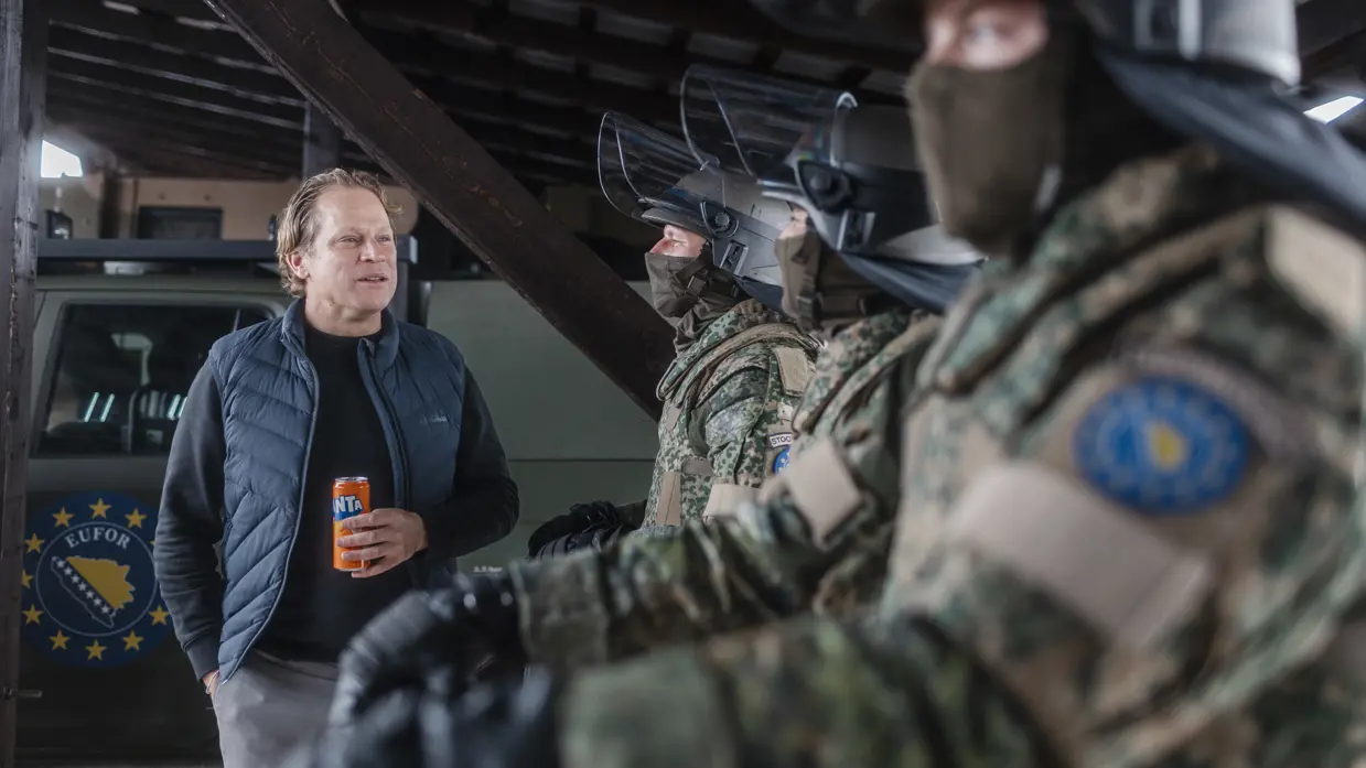  Staatssecretaris Tuinman praat met militairen in ME-tenue. Minister Brekelmans praat met een groepje marechaussees op Schiphol.
