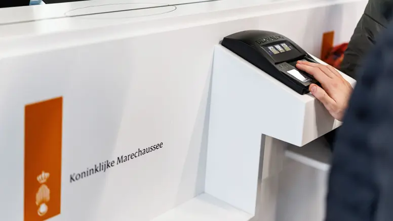 Een passagier geeft zijn vingerafdruk af.