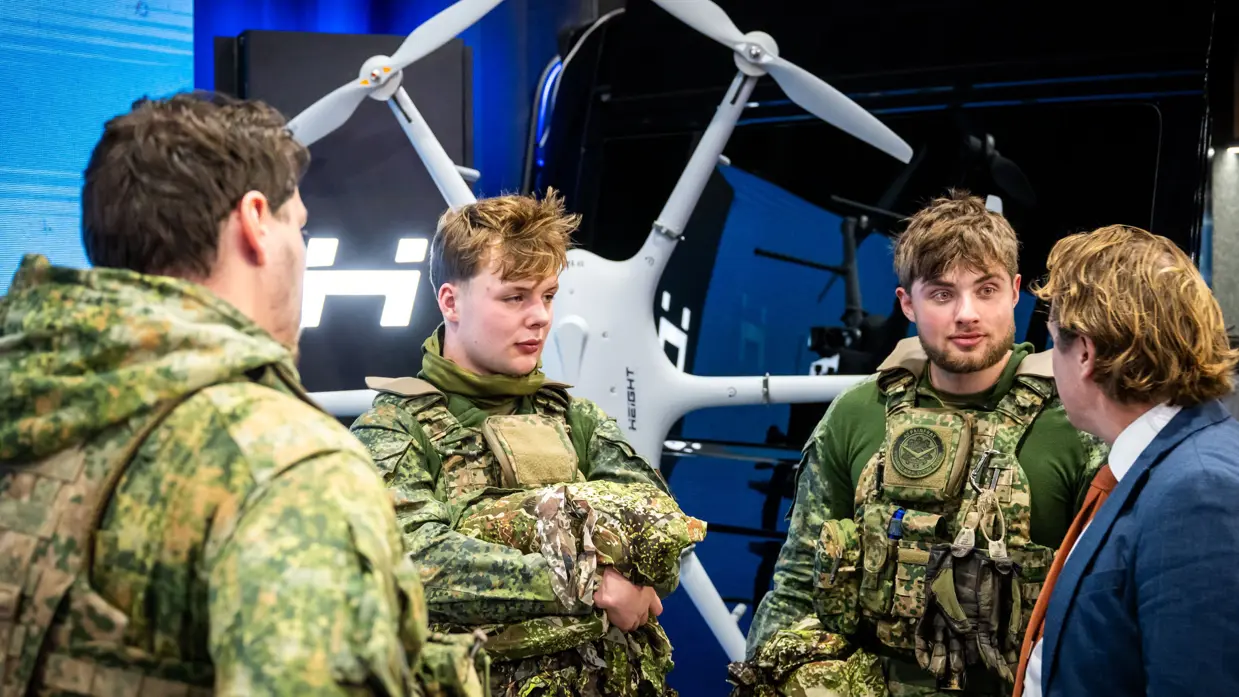 Tuinman in gesprek met 3 jonge militairen.