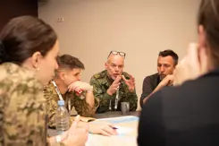 Militairen in gesprek aan een tafel.