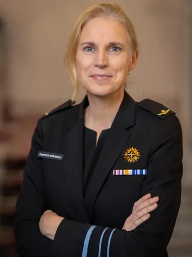 Boekholt-O’Sullivan geeft premier Jetten een hand. Op de andere foto is ze nog te zien in een donker defensie-uniform.