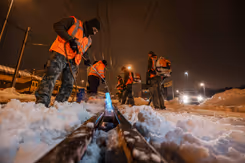 Militairen maken het spoor sneeuwvrij met een brander.
