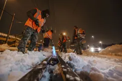 Militairen maken het spoor sneeuwvrij met een brander.