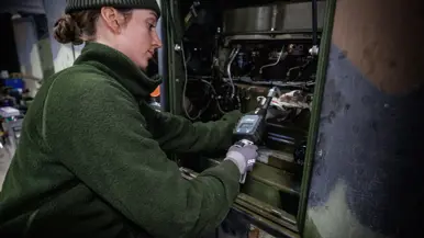 Op de linkerfoto sleutelt een monteur aan een aggregaat. Rechts staat op de voorgrond een aggregaat en op de achtergrond een lanceerinstallatie.