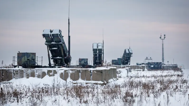 Drie lanceerinstallaties in een besneeuwd landschap. De lanceerbuizen omhoog gericht. 