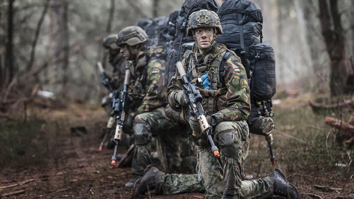 Deelnemers aan de NWT zitten op hun knieen in het bos.
