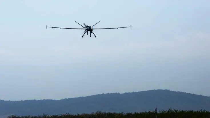 MQ-9 Reaper in de lucht, boven heuvelachtig terrein