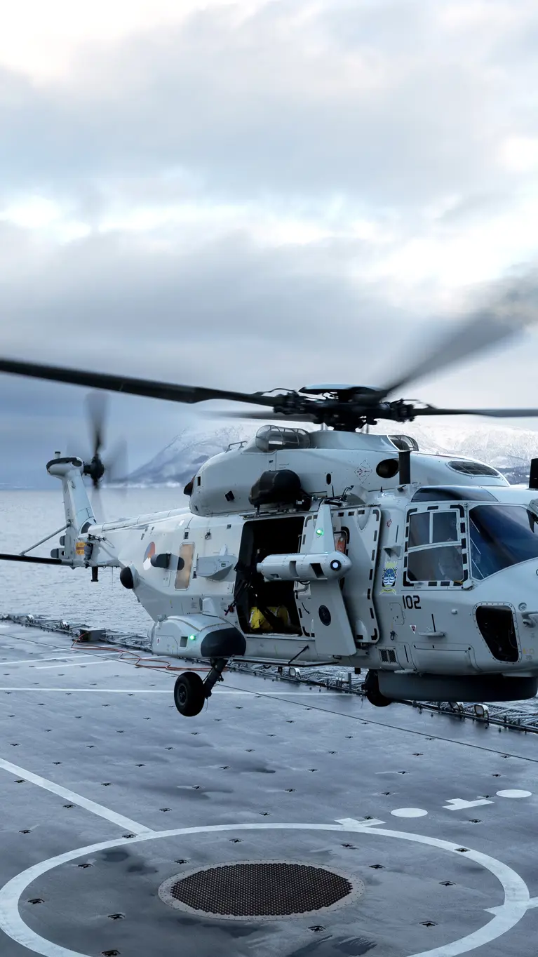 Een NH90 landt op het helikopterdek van een schip.