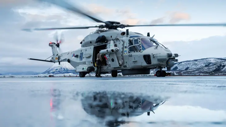 Een NH90 weerspiegelt in het smeltwater op het vliegdek van Zr.MS.Johan de Witt.