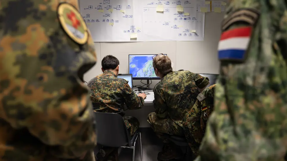 Militairen op de rug gezien, ze kijken naar een scherm.