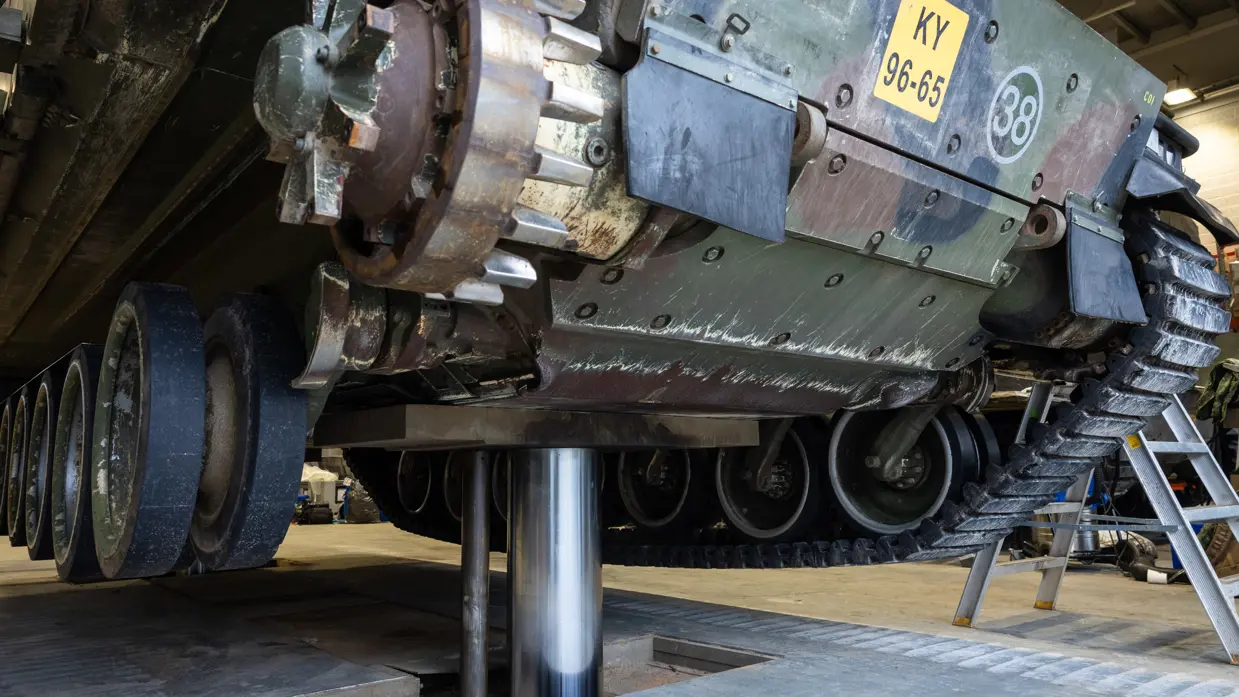  Een militair voertuig staat op een metalen paal.