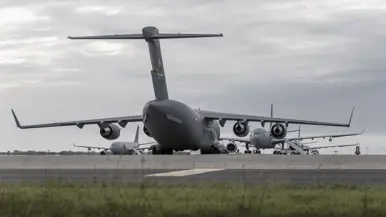 een C-17 transportvliegtuig staat vanaf de achterkant gezien voor 3 A330 MRTT’s.