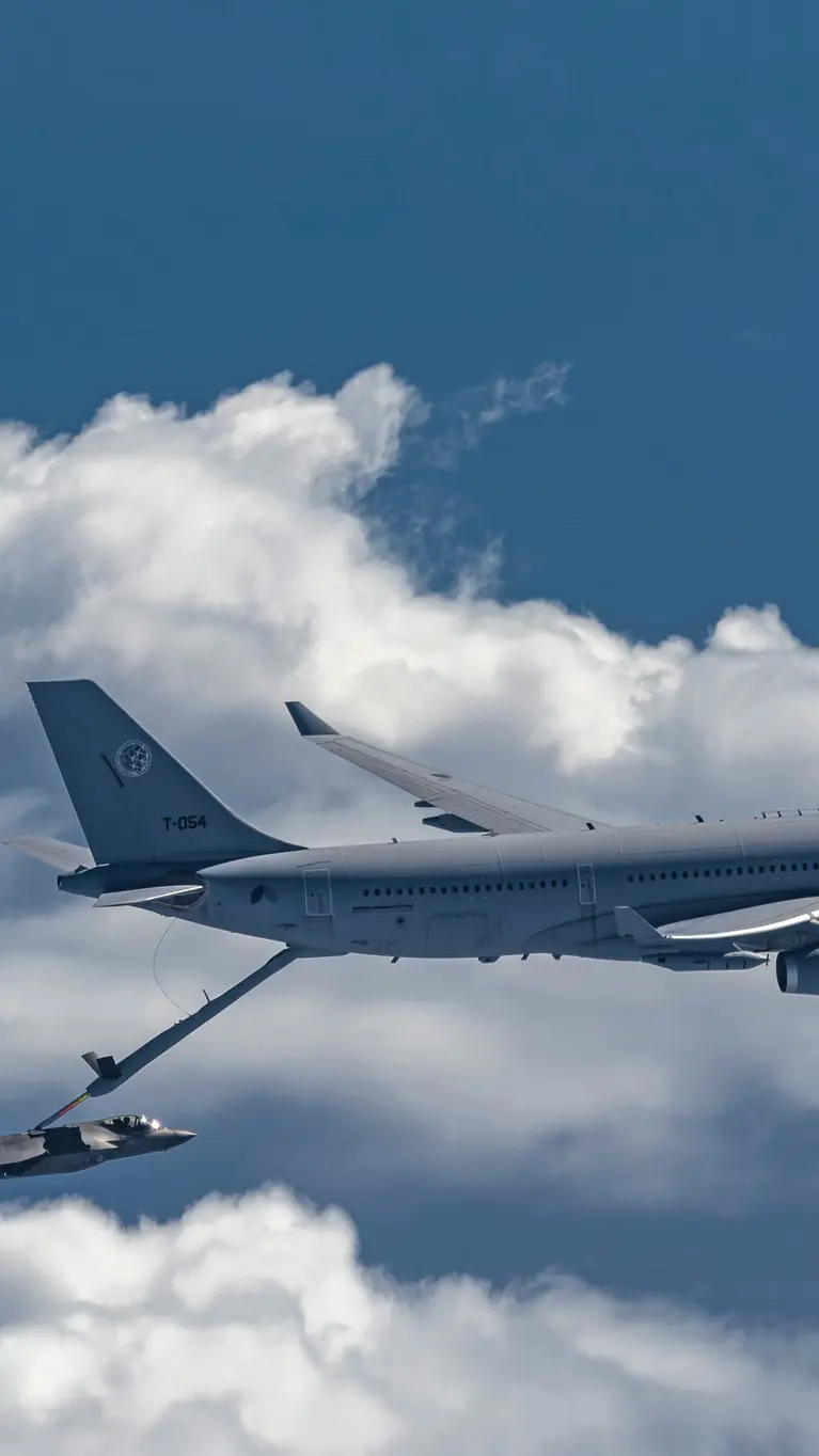 Een A330 MRTT tankt boven een wolkendek een F-35 bij.