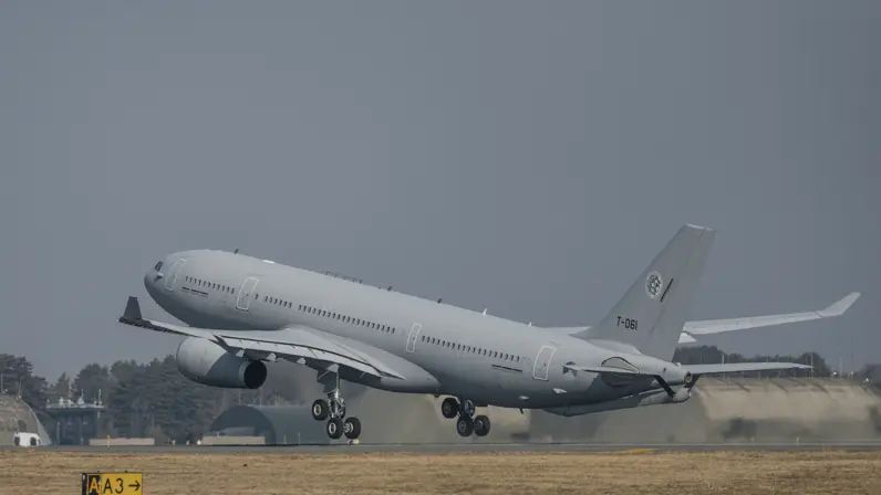 Het MRTT tankvliegtuig stijgt op. In de achtergrond zijn betonnen vliegtuigbunkers te zien.