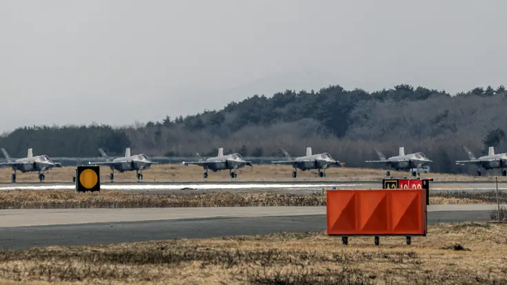 Een lijn van acht F-35’s naast elkaar op de kop van de startbaan