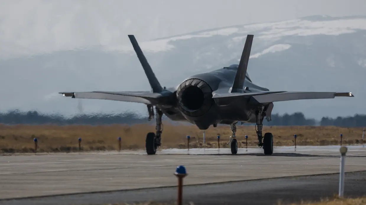 Een Japanse F-35 taxiet. In de achtergrond zijn besneeuwde bergen te zien. 