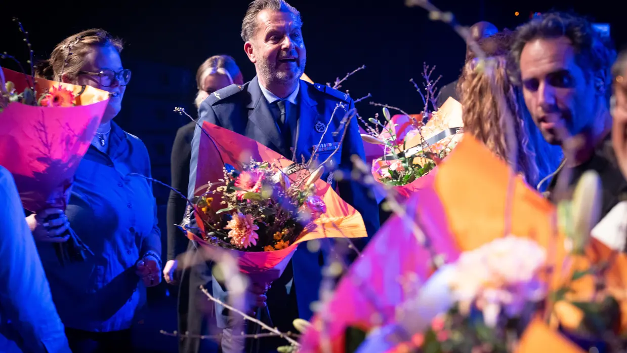 Majoor Toine Jongbloets ontvangt bloemen op het podium na afloop van het jubileumconcert.