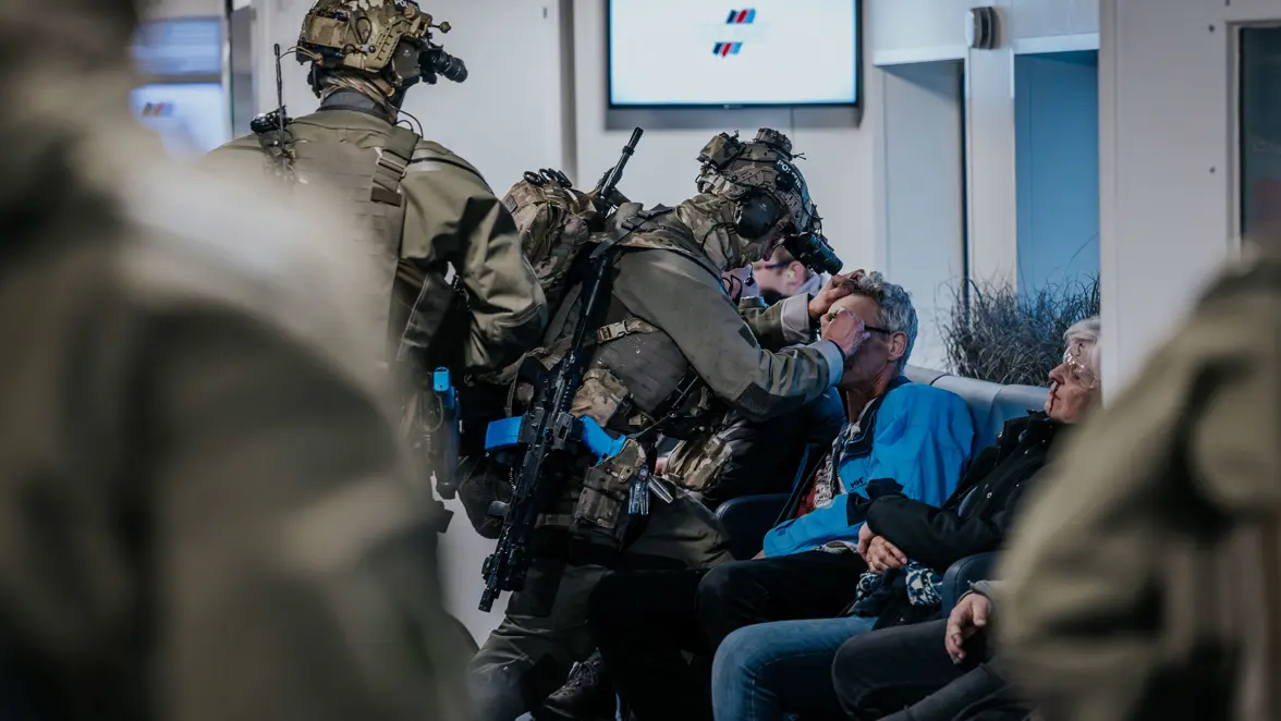 Een operator checkt de pupilreactie van een gewonde passagier aan boord van de veerboot.