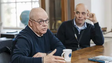 Open boek op houten tafel: links een oude gravure van een soldaat, rechts een titelpagina van een Frans woordenboek. 