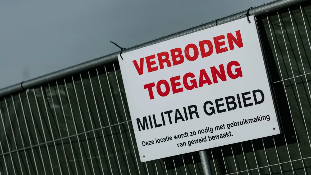Wit bord met daarop de tekst: verboden toegang, militair gebied. 