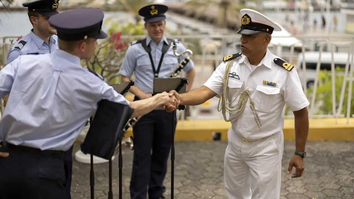 Lid van de marine schudt hand muzikant van KLu-orkest. 