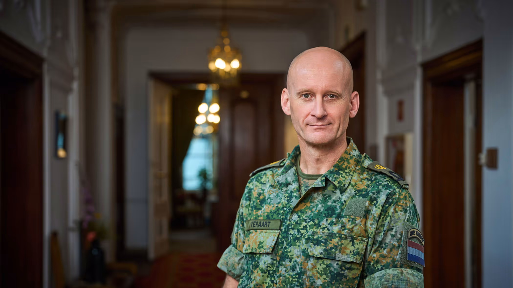 Militair in uniform staat in statige gang ministerie.
