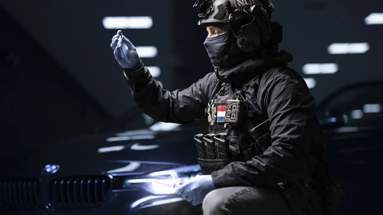 Operator in tactische uitrusting inspecteert medische apparatuur.