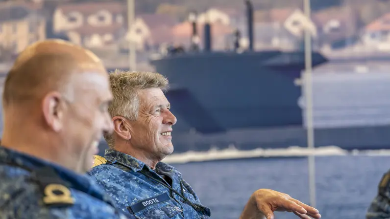 2 zittende marinemensen voeren zienderogen een geanimeerd gesprek.&nbsp;