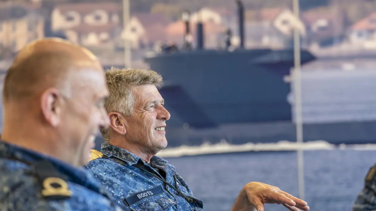 2 zittende marinemensen voeren zienderogen een geanimeerd gesprek.&nbsp;