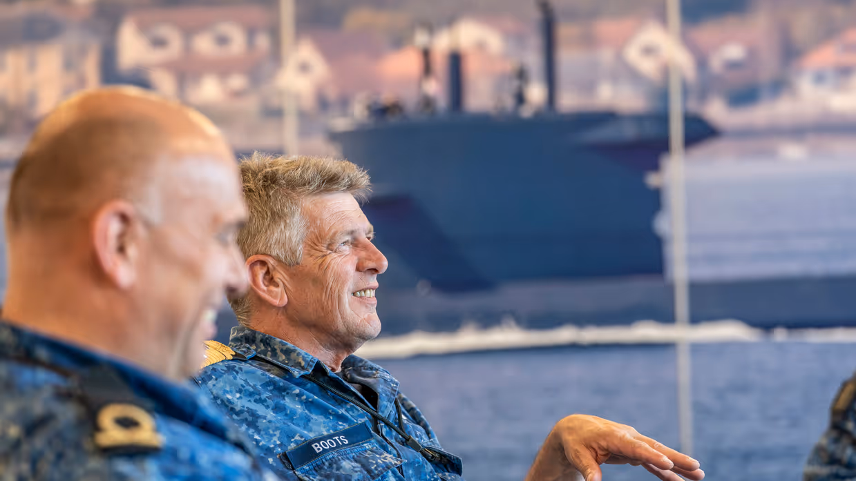 2 zittende marinemensen voeren zienderogen een geanimeerd gesprek.&nbsp;
