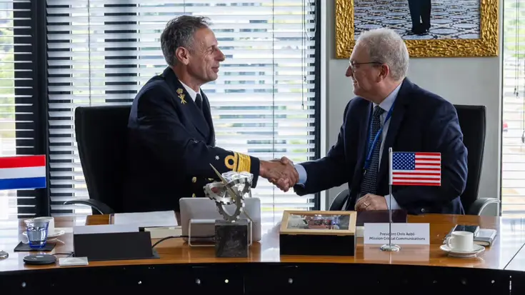 Militair en afgevaardigde bedrijf geven elkaar de hand na ondertekening overeenkomst.