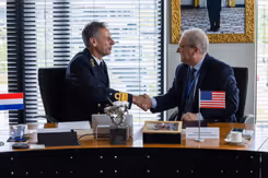 Militair en afgevaardigde bedrijf geven elkaar de hand na ondertekening overeenkomst.