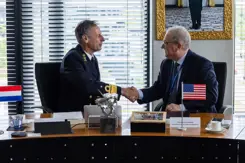 Militair en afgevaardigde bedrijf geven elkaar de hand na ondertekening overeenkomst.
