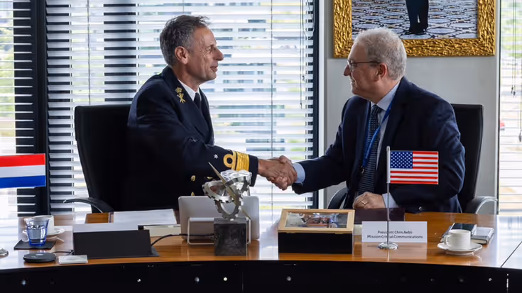Militair en afgevaardigde bedrijf geven elkaar de hand na ondertekening overeenkomst.