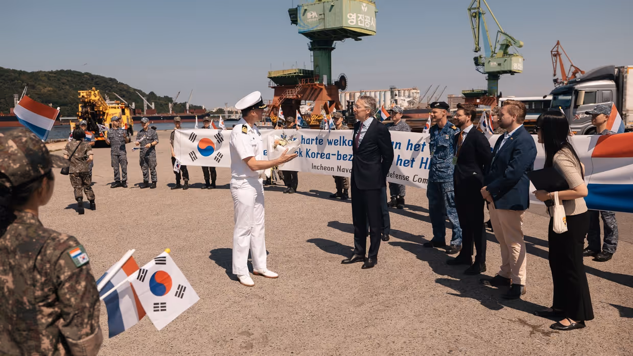 Een groep Nederlandse vertegenwoordigers wordt verwelkomd door een Koreaanse militair.
