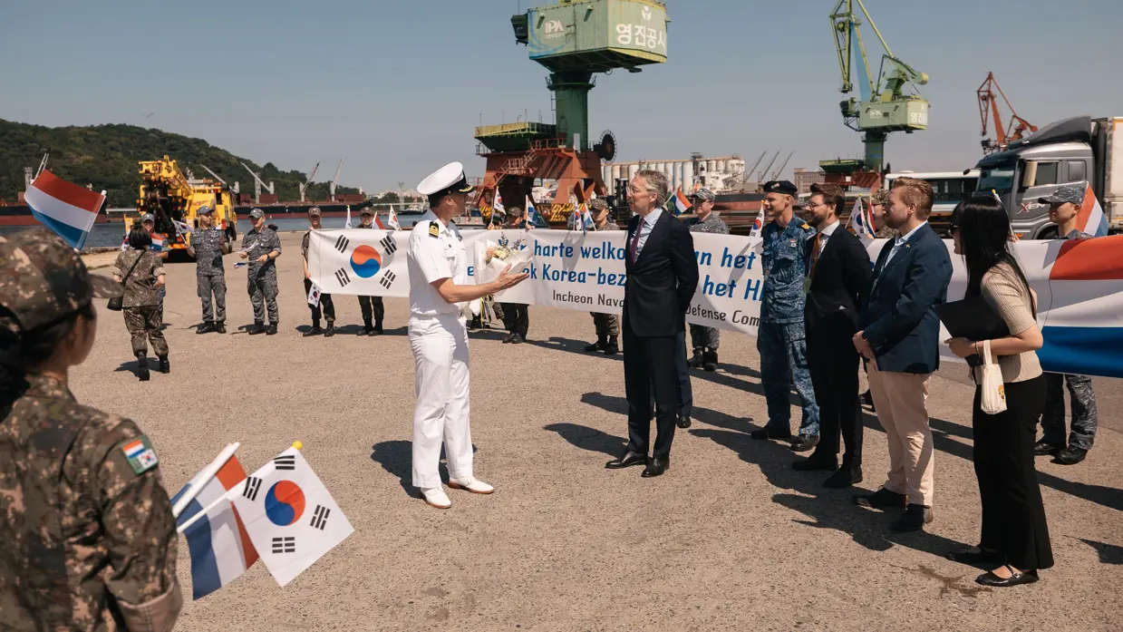 Een groep Nederlandse vertegenwoordigers wordt verwelkomd door een Koreaanse militair.